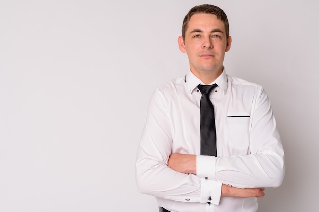 Portrait of handsome businessman against white wall