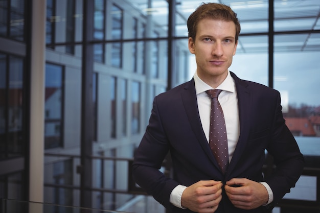 Portrait of handsome businessman standing in corridor