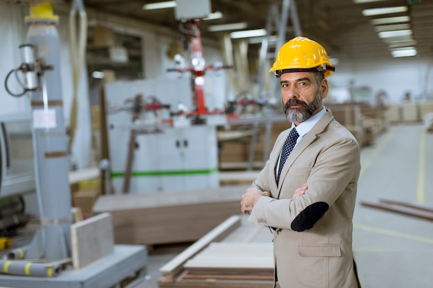 Portrait of handsome businessman in suit with helmet in a warehouse