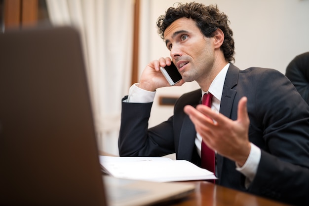 Portrait of an handsome businessman talking on the phone