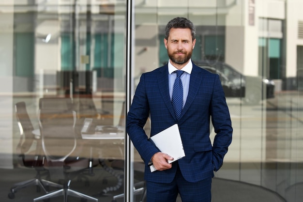 Portrait of handsome businessman using laptop outdoor