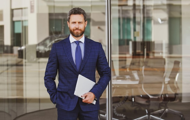 Portrait of handsome businessman using laptop outdoor