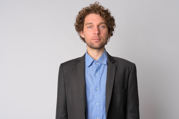 Portrait of handsome businessman with curly hair on white