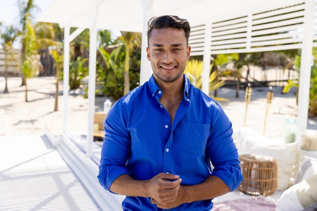 Foto ritratto di un bel giovane caucasico che indossa una camicia blu in piedi nella località turistica, copia spazio. inalterato, vacanza, sorriso, stile di vita e concetto di divertimento.