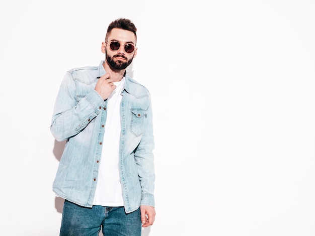 Portrait of handsome confident model Sexy stylish man Fashion hipster male posing near wall in studio