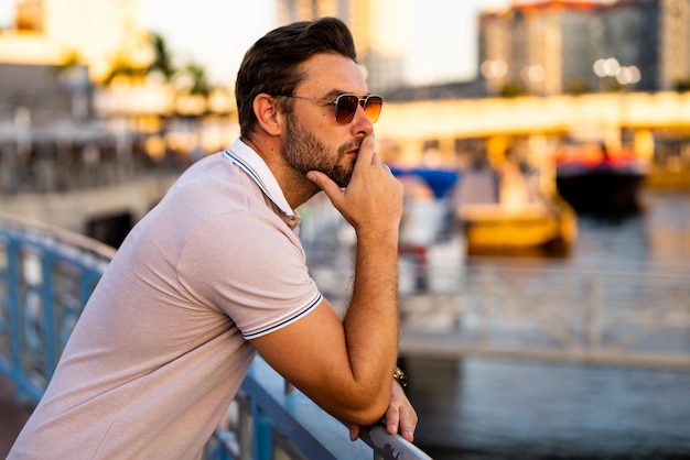 Portrait of handsome confident stylish man in big city sexy man in casual clothes posing on the stre