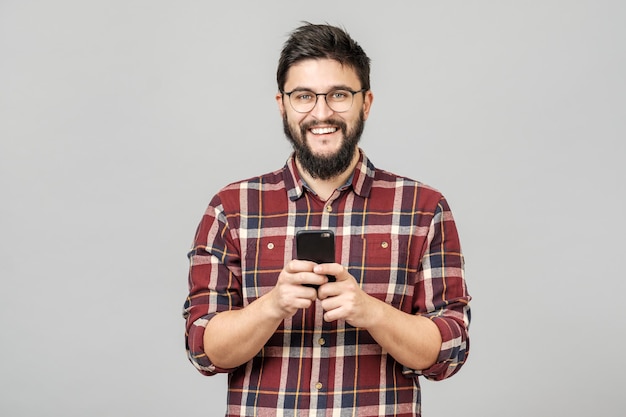 portrait of handsome european man holding telephone while texting