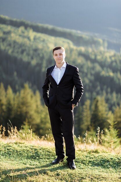 Portrait of a handsome groom posing outdoors on his wedding day.