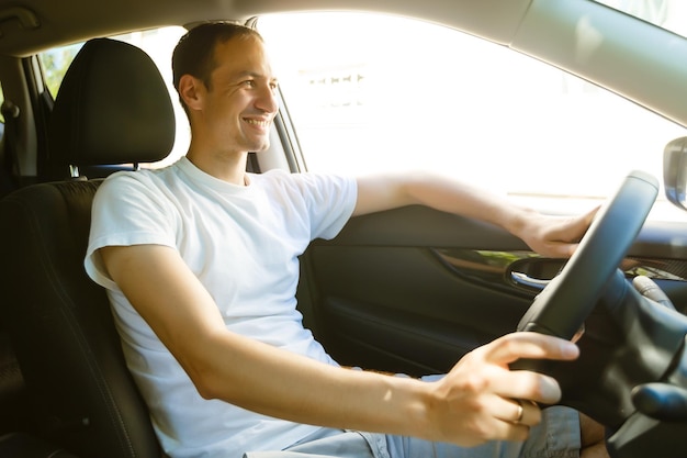 Portrait of an handsome guy driving his car