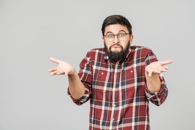 Portrait of handsome guy looking upside and shrugging his shoulders