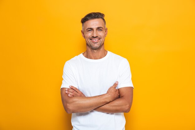 Portrait of a handsome happy excited man posing isolated on yellow wall.