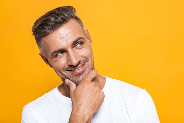 Portrait of a handsome happy excited man posing isolated on yellow wall.