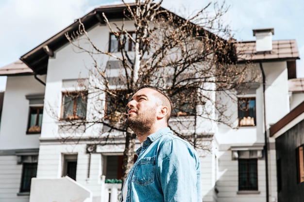 Portrait of a handsome hipster man in a jean jacket A man in a big city on the street a life style