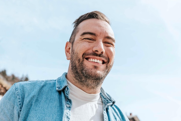 Portrait of a handsome hipster man in a jean jacket A man in a big city on the street a life style