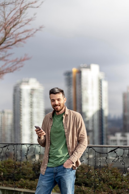 Portrait of handsome hispanic man wearing casual clothing holding smartphone communication online