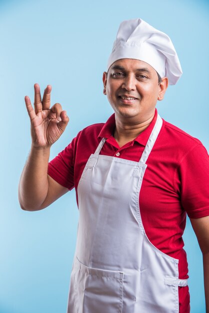 Portrait of handsome Indian male chef posing while doing activities