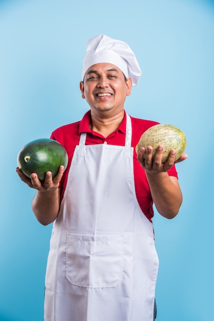 Portrait of handsome Indian male chef posing while doing activities