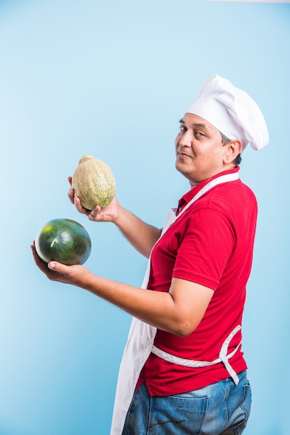 Portrait of handsome Indian male chef posing while doing activities