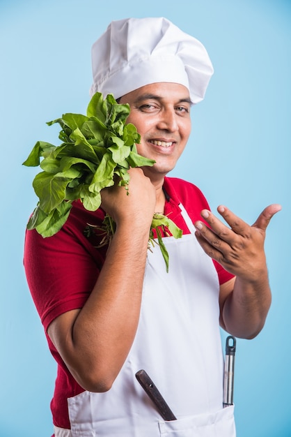 Portrait of handsome Indian male chef posing while doing activities