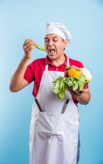 Portrait of handsome Indian male chef posing while doing activities