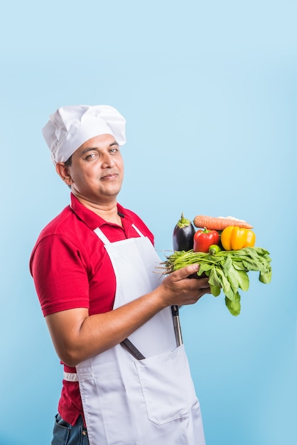 Portrait of handsome Indian male chef posing while doing activities