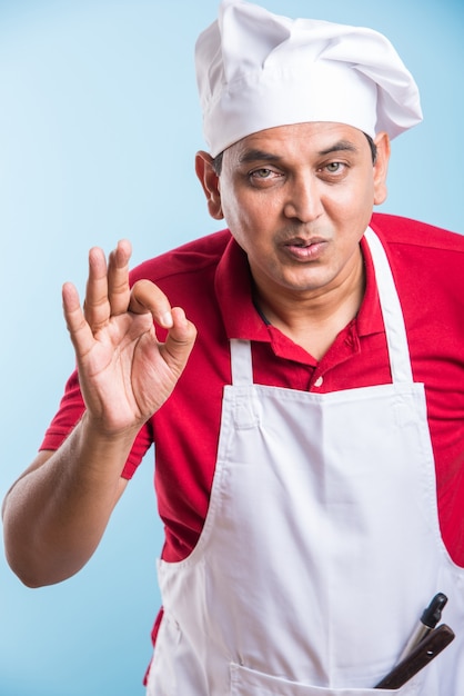 Portrait of handsome Indian male chef posing while doing activities