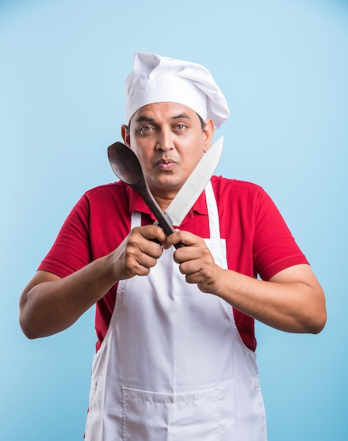 Portrait of handsome Indian male chef posing while doing activities