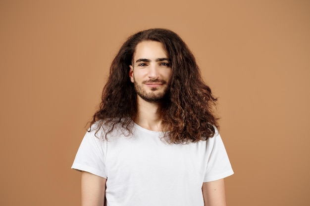 Portrait of handsome latin guy with long curly hair studio