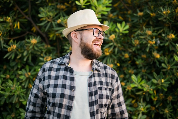 Portrait handsome laugh man over green bush outside  summer and emotional concept