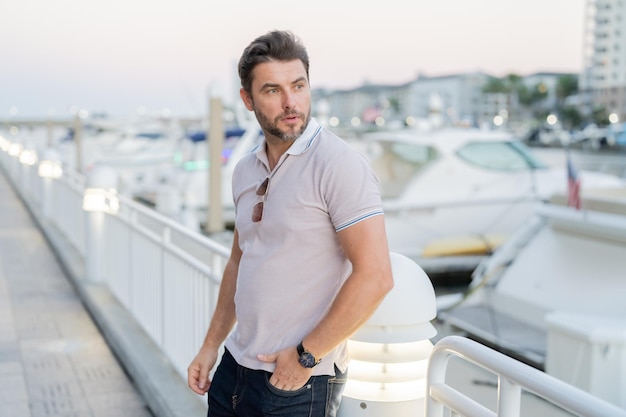 Portrait of handsome male model outdoor stylish man dressed in polo fashion male posing on the stree