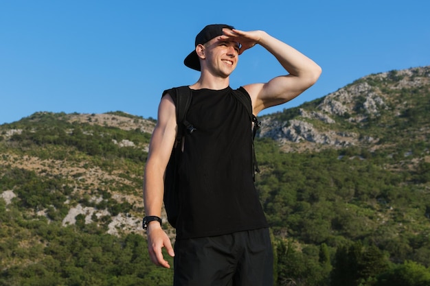 Portrait of a handsome man against the background of mountains Hiking in summer in good weather