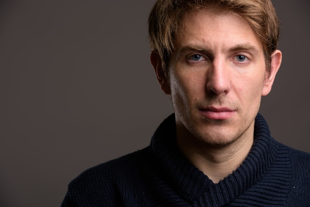 Portrait of handsome man against gray wall