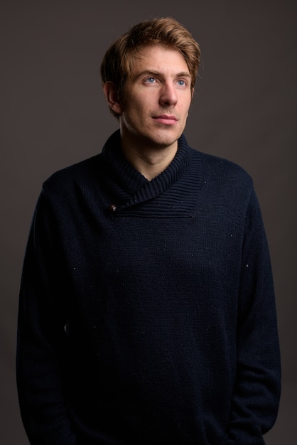 Portrait of handsome man against gray wall