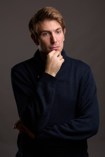 Portrait of handsome man against gray wall