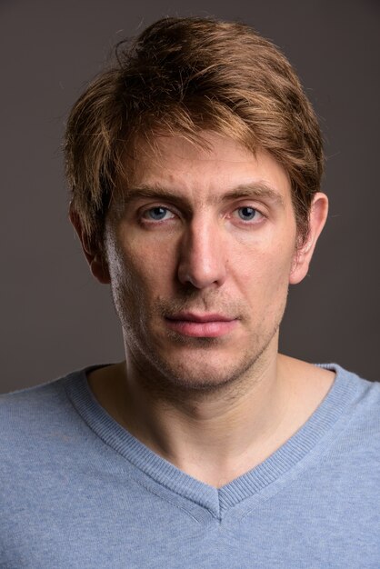 Portrait of handsome man against gray wall