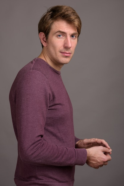 Portrait of handsome man against gray wall