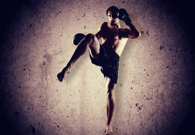 Portrait of handsome man boxing on background