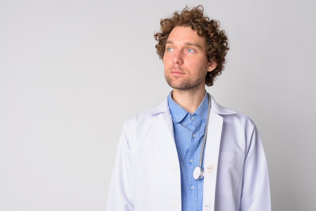 Portrait of handsome man doctor with curly hair on white