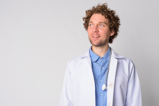 Portrait of handsome man doctor with curly hair on white