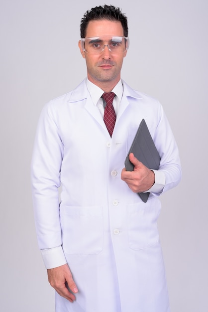 Foto ritratto di uomo bello medico con occhiali protettivi su bianco