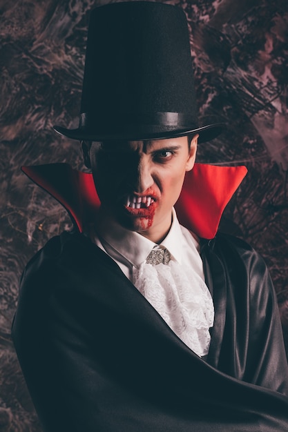 portrait of handsome man dressed in a dracula costume for halloween
