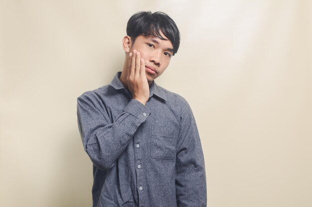 Portrait of handsome man in gray shirt with disappointed and sad expression