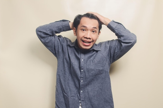 Portrait of handsome man in gray shirt with disappointed and sad expression