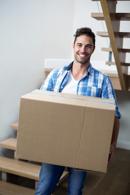 Portrait of handsome man holding box 