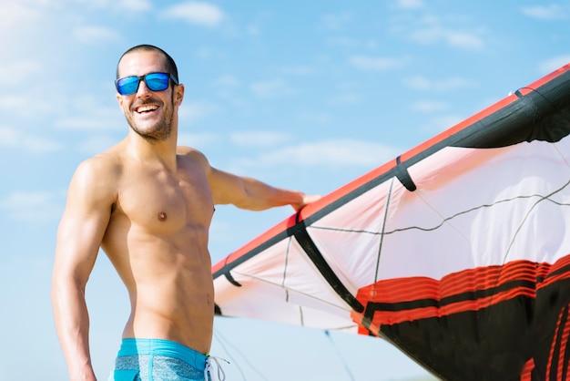 해변에서 잘 생긴 남자 kitesurfer의 초상화입니다.