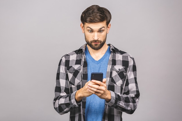 Portrait of handsome man looks shocked in smartphone