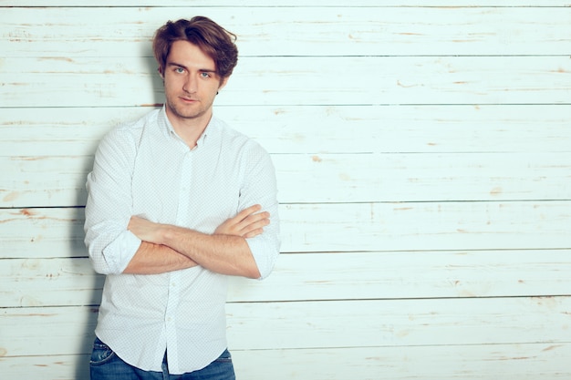 Portrait of a handsome man on old wooden wall