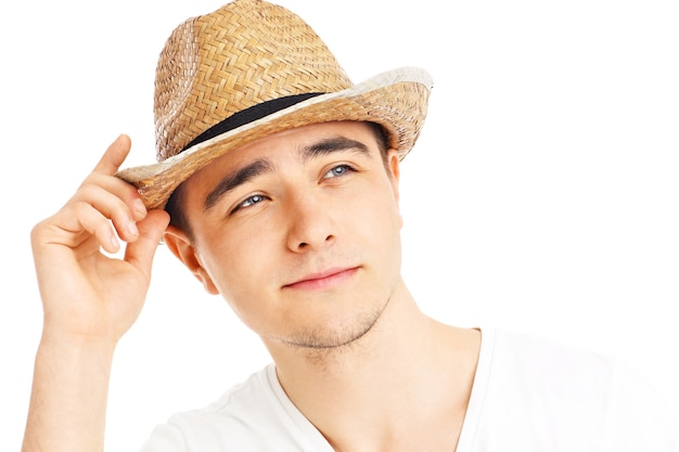 白い背景の上の夏の帽子でポーズをとってハンサムな男の肖像画