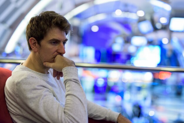 Portrait of handsome man relaxing at the coffee shop inside the mall in the city of Bangkok, Thailand