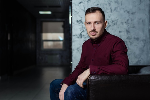 Portrait of a handsome man sitting in armchair